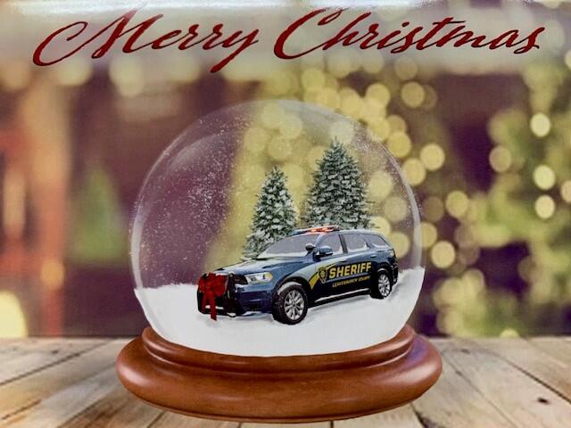 BLUE suv VEHICLE INSIDE SNOWGLOBE SURROUNDED BY FIR TREES TITLED HAPPY HOLIDAYS